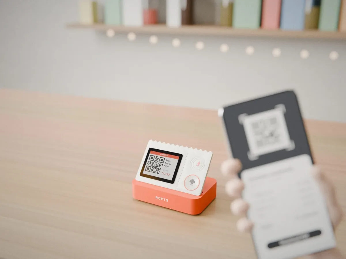 The rcpts counter device showing a QR code while a customer scans it with a phone